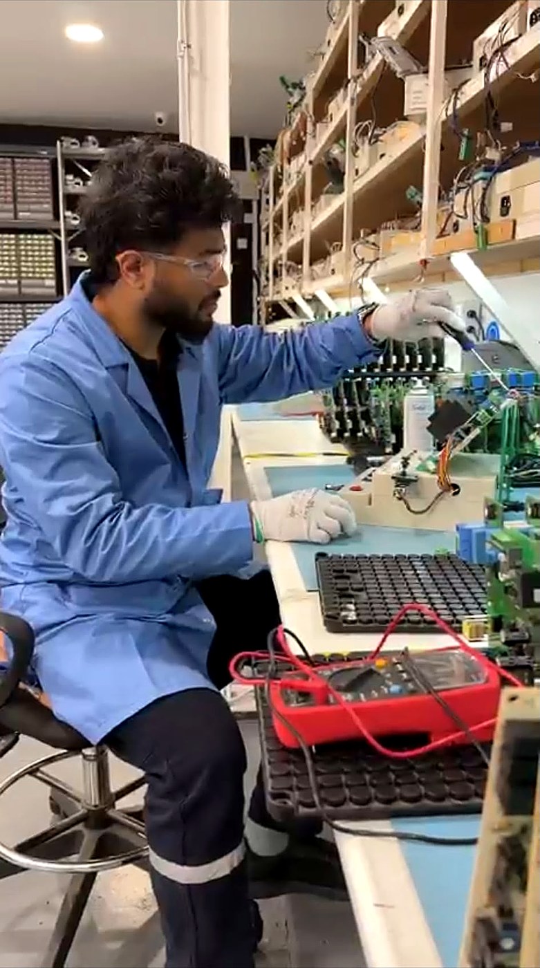 Mohammed Aneesuddin testing electronic control boards at a lab bench